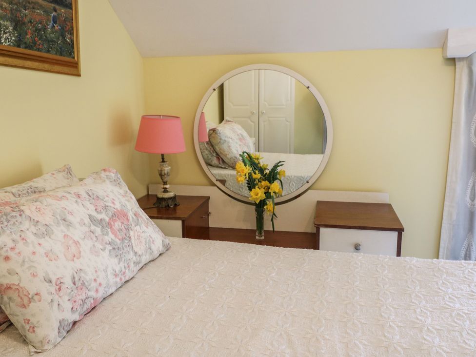 A bedroom with a bed and a mirror at The Farmhouse in Dunmanway, County Cork