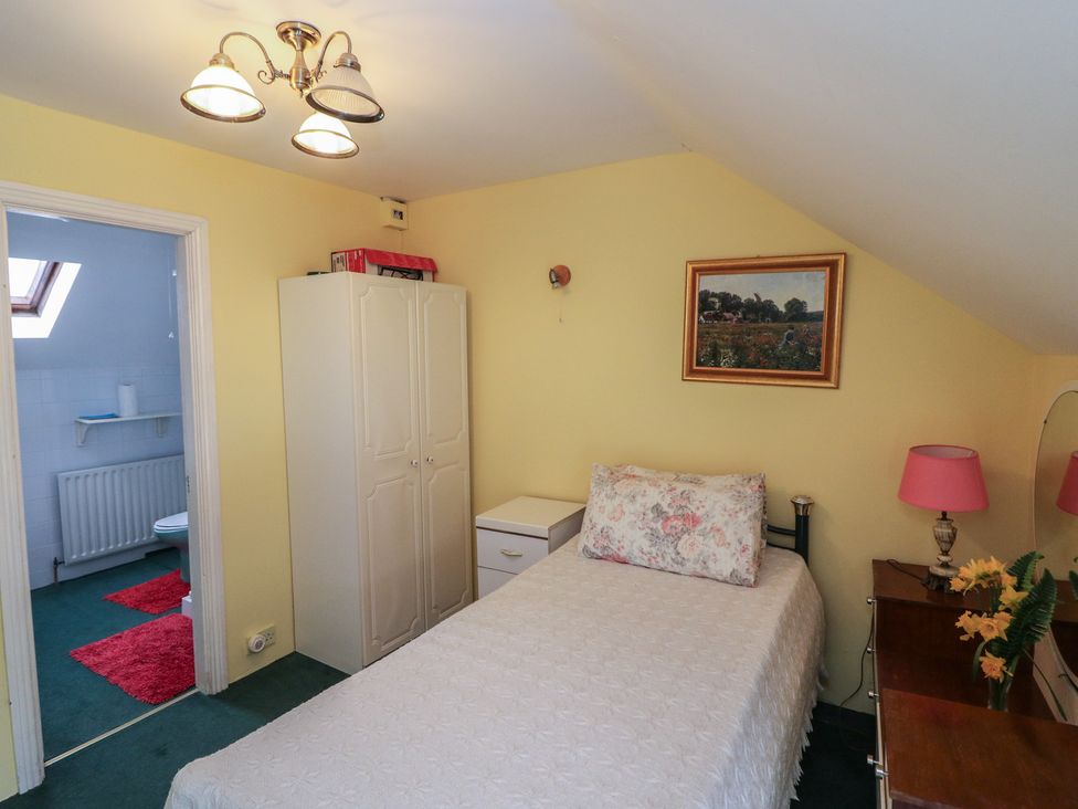 A bedroom with a bed and wardrobe at The Farmhouse in Dunmanway, County Cork