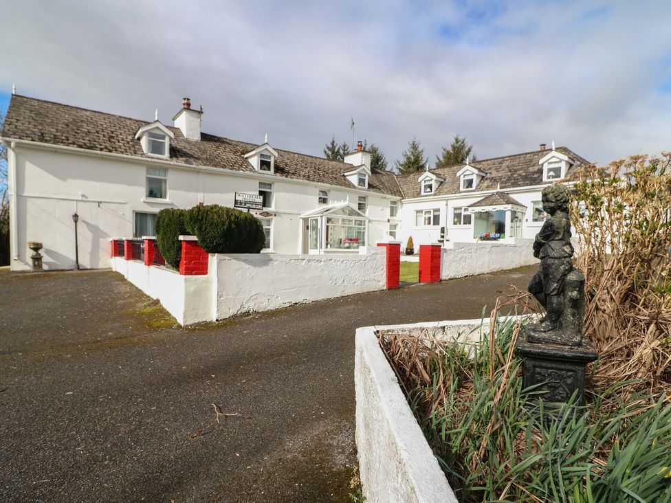 An outdoor view of a building with a statue at The Farmhouse in Dunmanway, County Cork