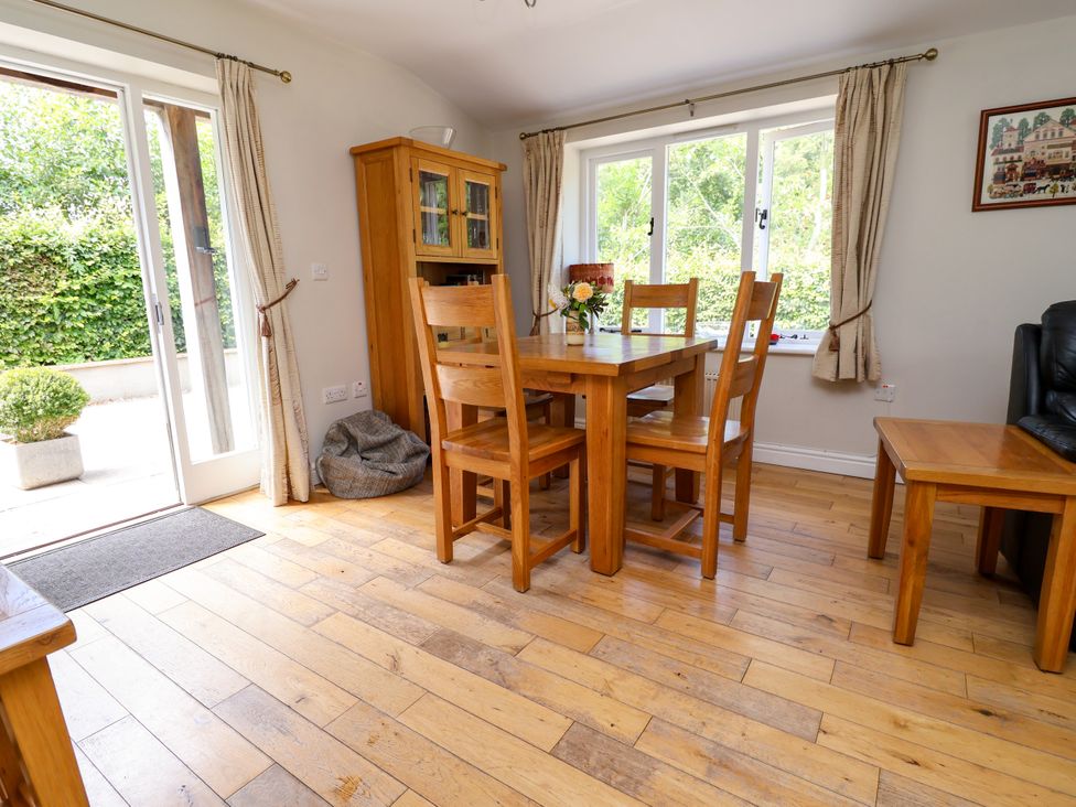 A dining room with a wooden table and chairs at The Lambing Shed in Dyserth near Prestatyn