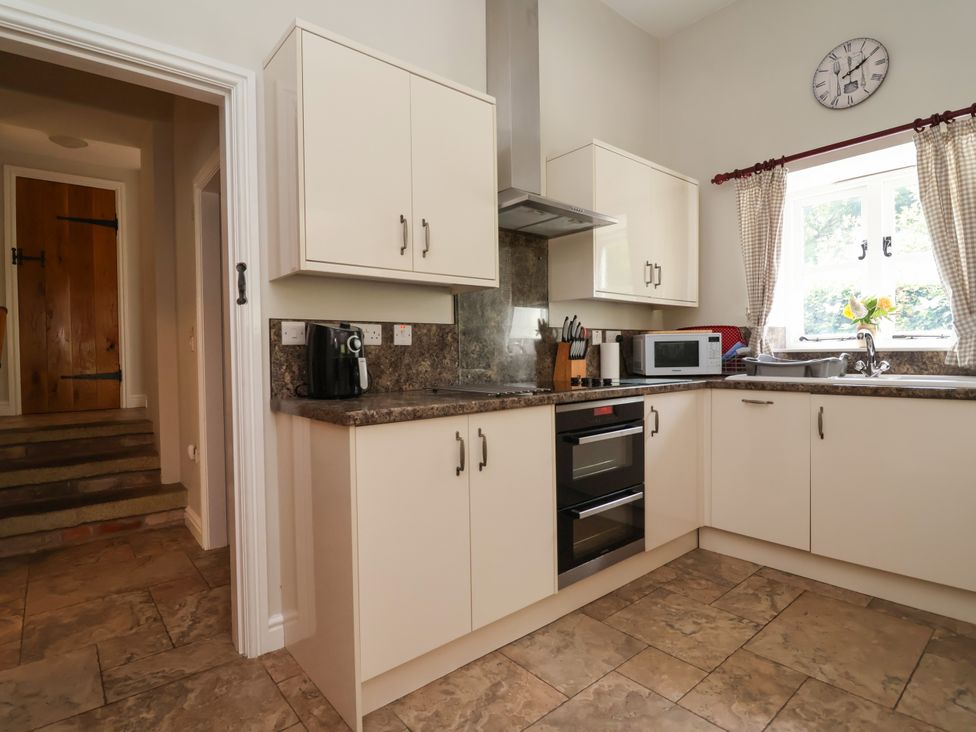A kitchen with cabinets, sink, microwave, and oven at The Lambing Shed Dyserth near Prestatyn