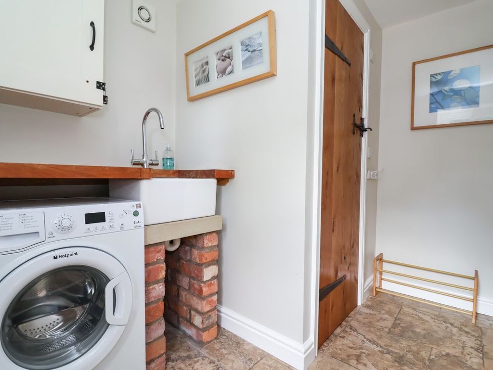 A laundry room with a washing machine and sink at The Lambing Shed in Dyserth near Prestatyn