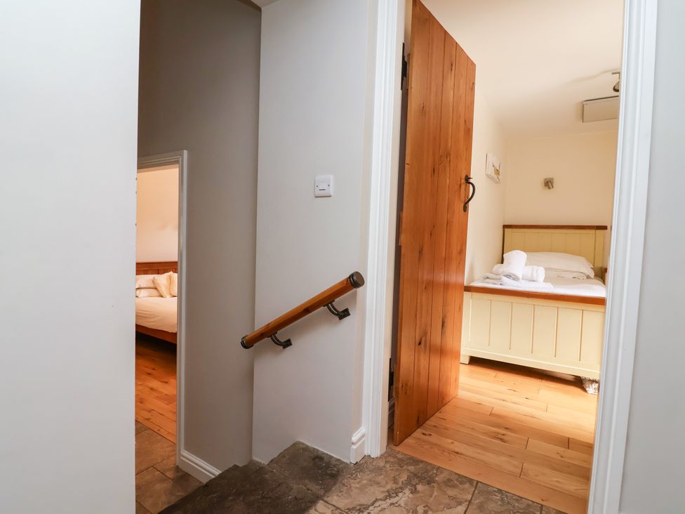 A staircase leading to a bedroom with a bed in The Lambing Shed Dyserth near Prestatyn