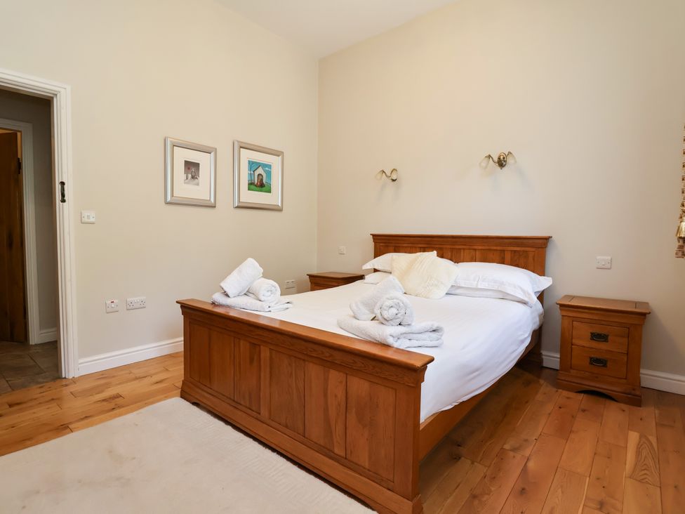 A bedroom with a wooden bed and bedside table at The Lambing Shed Dyserth near Prestatyn