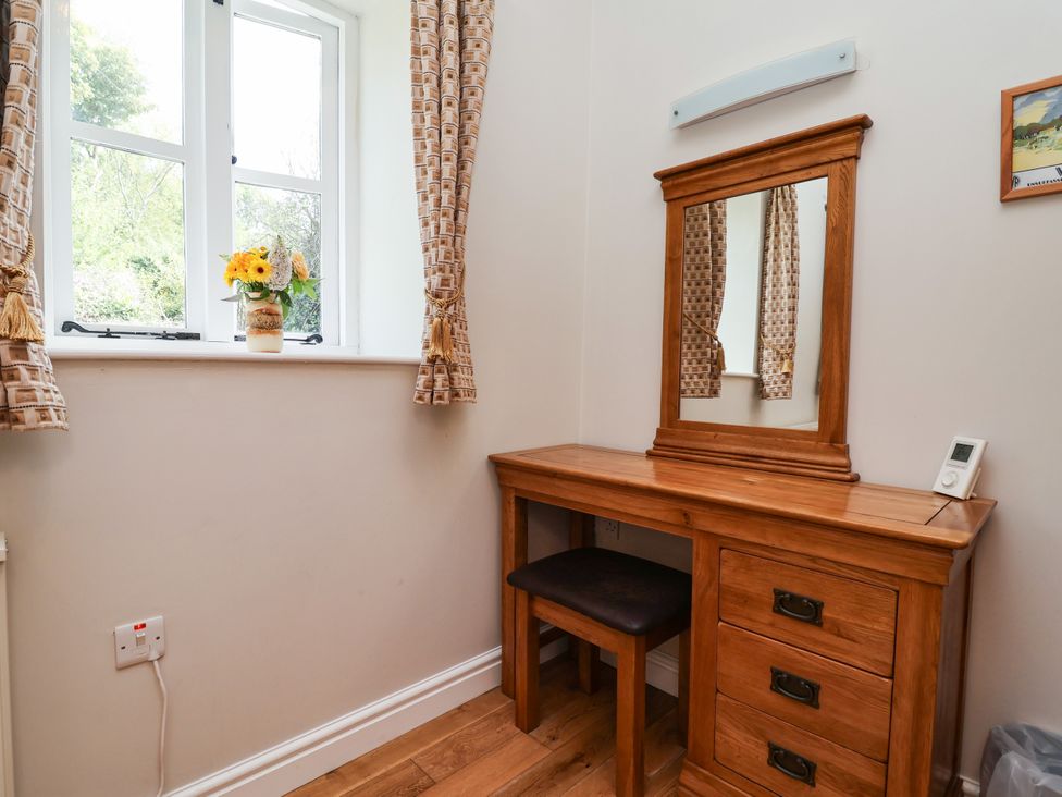 A dressing room with a dressing table and mirror at The Lambing Shed in Dyserth near Prestatyn