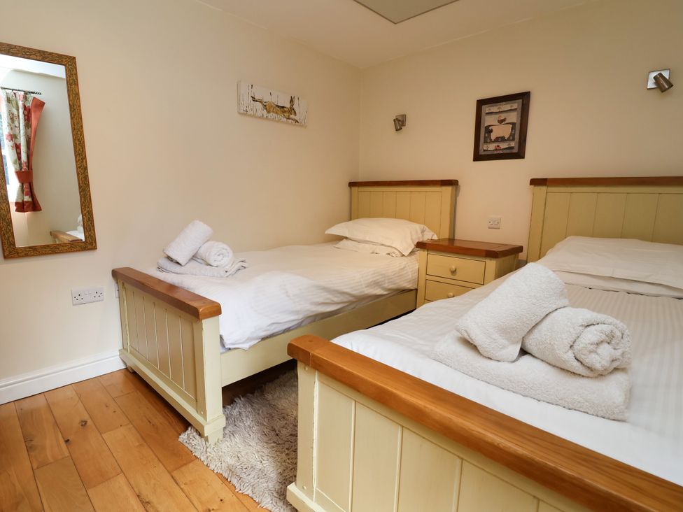 A bedroom with two beds and a mirror at The Lambing Shed Dyserth near Prestatyn