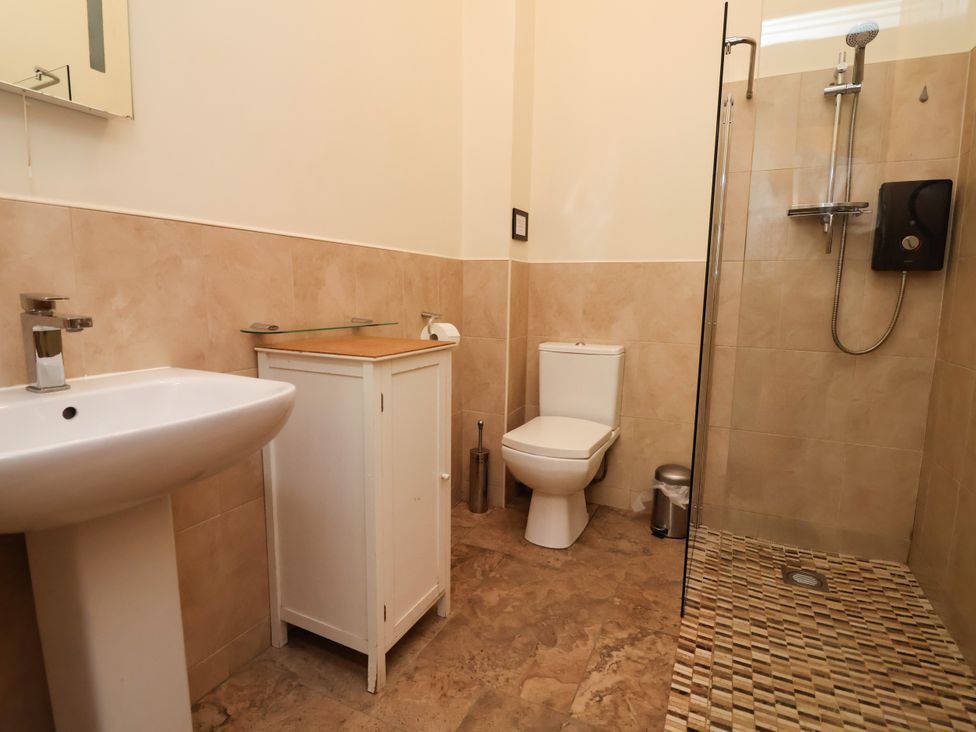 A bathroom featuring a sink, toilet, shower and cabinet at The Lambing Shed Dyserth near Prestatyn