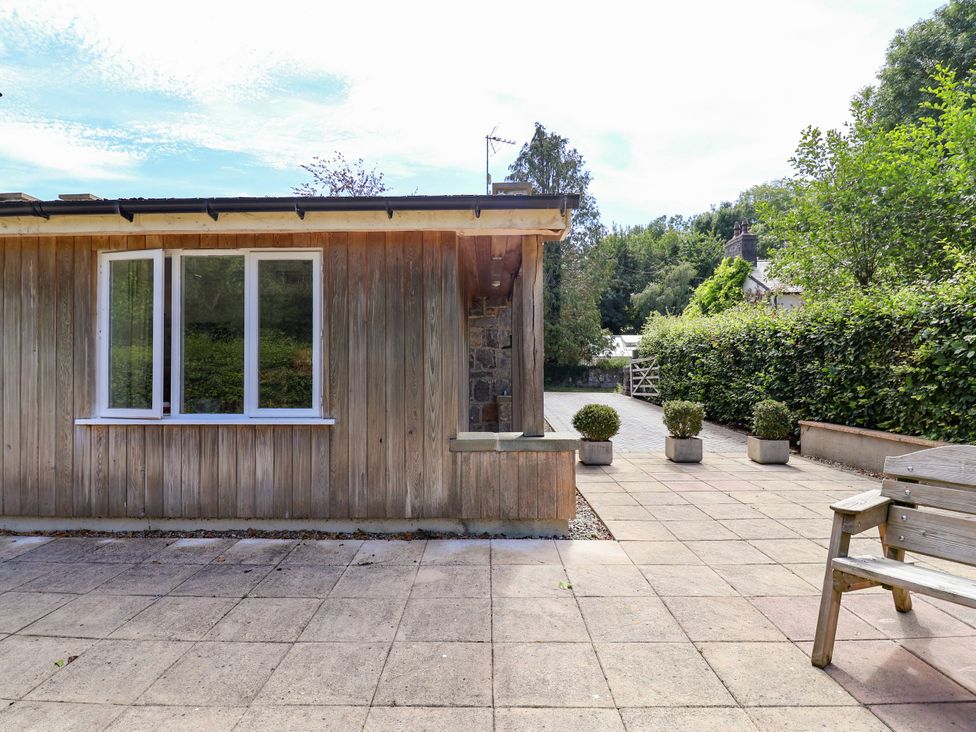 An outdoor area with a wooden wall and potted plants at The Lambing Shed Dyserth near Prestatyn
