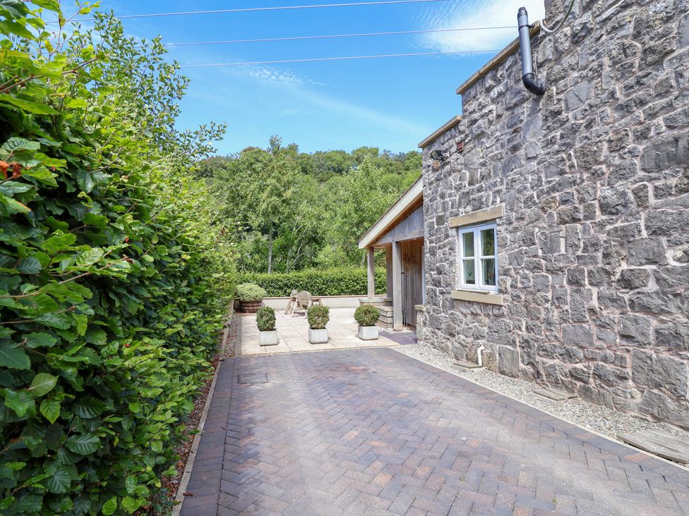 An outdoor space with a paved pathway and planters at The Lambing Shed in Dyserth near Prestatyn
