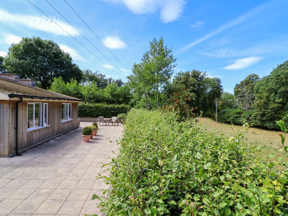 An outdoor area with a terrace and hedge at The Lambing Shed in Dyserth near Prestatyn