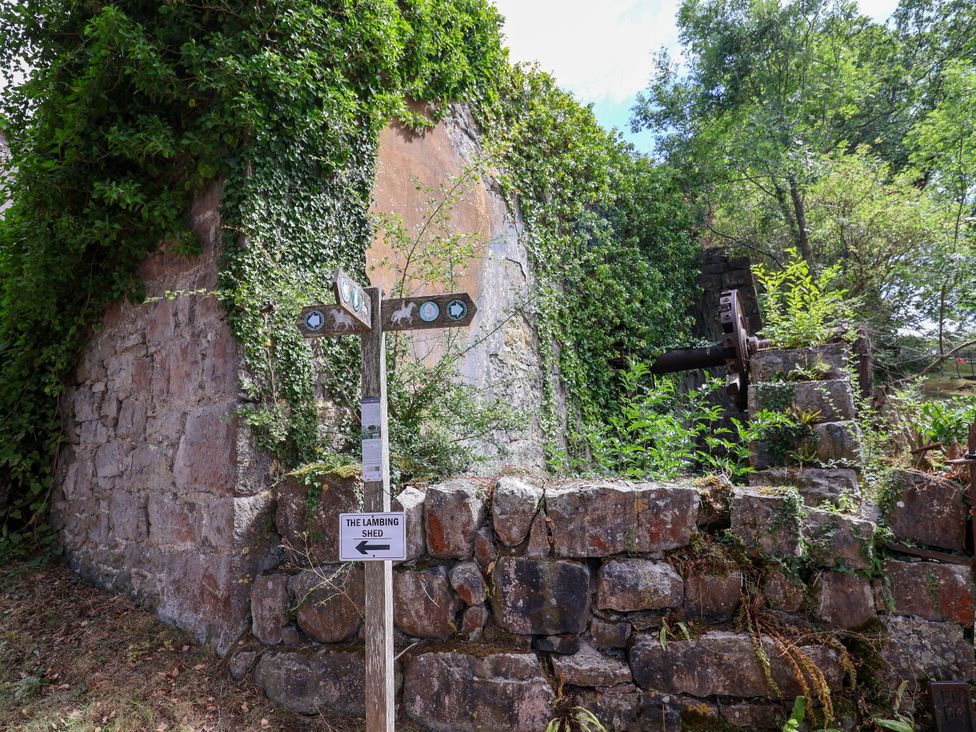 An outdoor area with a signpost and stone wall at The Lambing Shed Dyserth near Prestatyn
