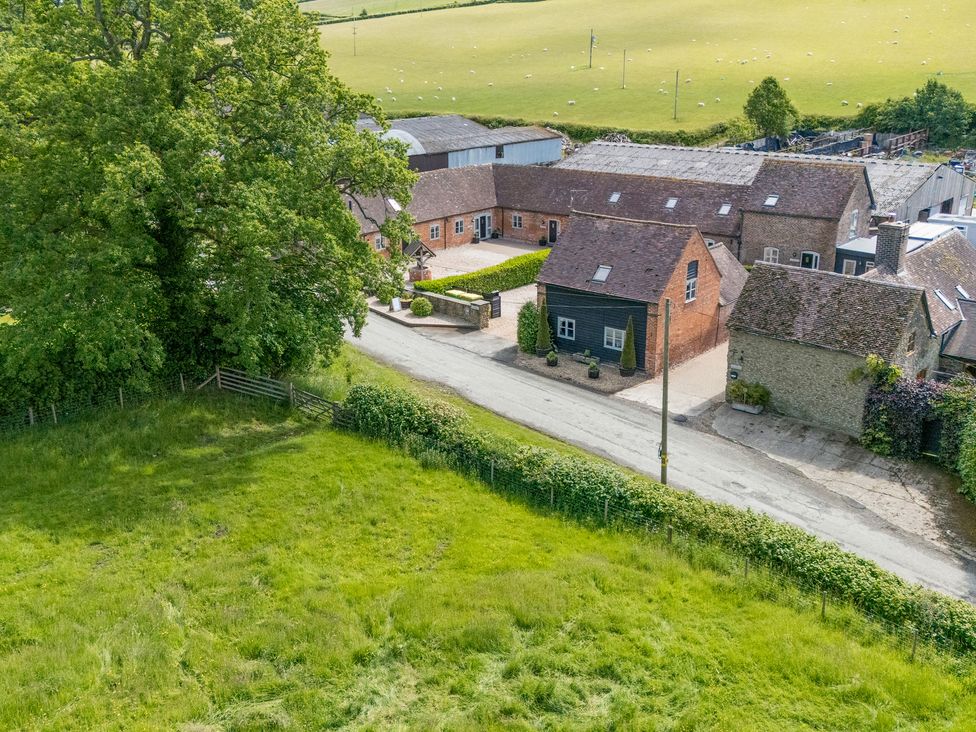An outdoor view of buildings and a field at The Olde Cowshed in Westhope near Church Stretton