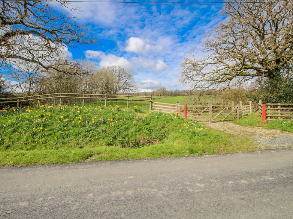 An outdoor view of a gate and flowers at The Olde Cowshed in Westhope near Church Stretton