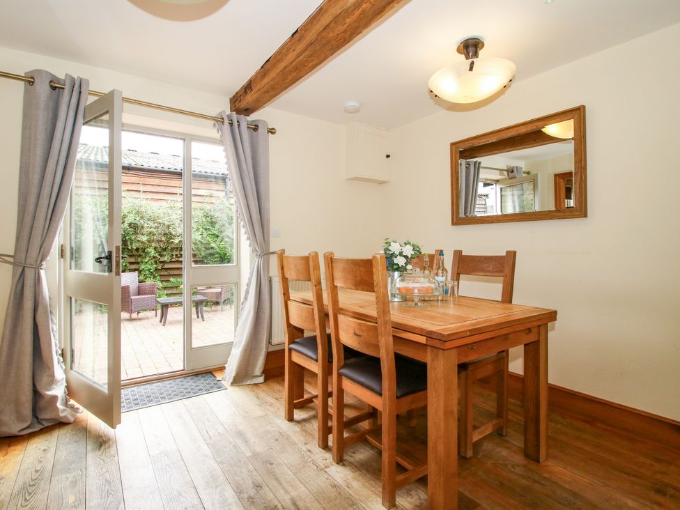 A dining room with a wooden table and chairs at The Olde Cowshed in Westhope near Church Stretton