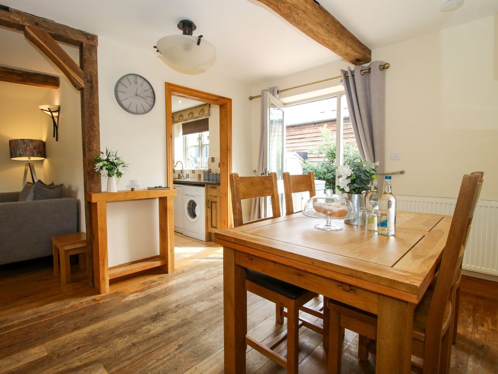 A dining room with a table and chairs visible at The Olde Cowshed in Westhope near Church Stretton
