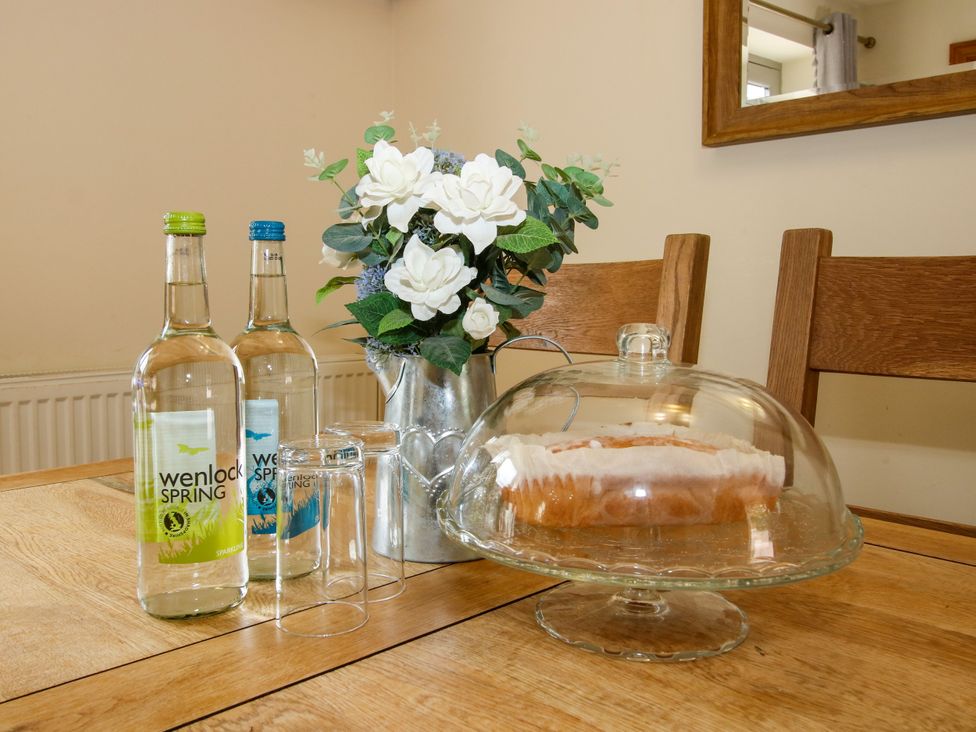A dining room table with drinks and cake at The Olde Cowshed in Westhope near Church Stretton