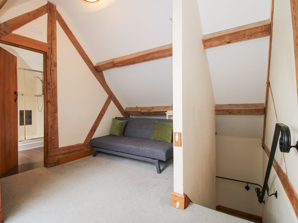 A landing area with a sofa and staircase at The Olde Cowshed in Westhope near Church Stretton