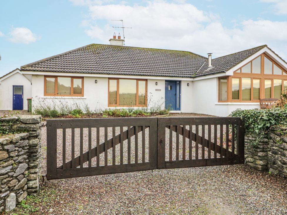 A house with a wooden gate and gravel driveway at Lough Cluhir Cottage Union Hall, County Cork