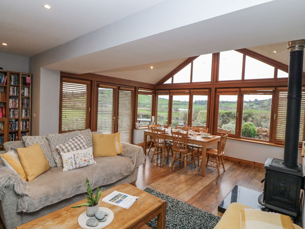 A living room with a dining area at Lough Cluhir Cottage in Union Hall, County Cork
