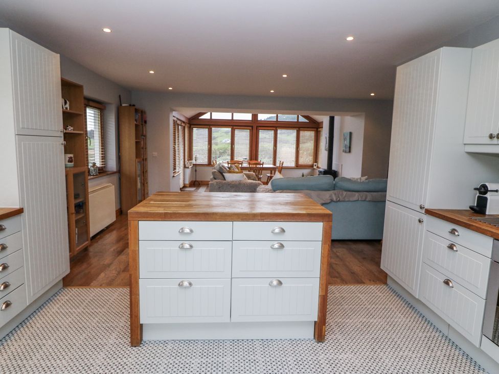 A kitchen with cabinets and an island at Lough Cluhir Cottage, Union Hall, County Cork