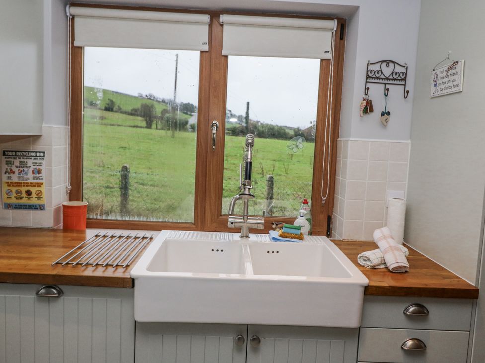A kitchen with a sink and window at Lough Cluhir Cottage in Union Hall, County Cork