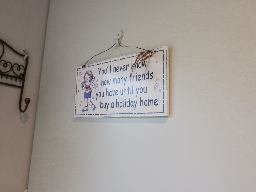A sign hanging on a wall with text about buying a holiday home at Lough Cluhir Cottage, Union Hall, County Cork
