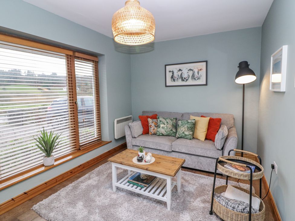 A living room with a sofa and a coffee table at Lough Cluhir Cottage, Union Hall, County Cork