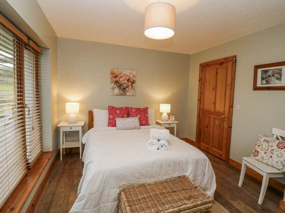 A bedroom with a bed and side tables at Lough Cluhir Cottage, Union Hall, County Cork