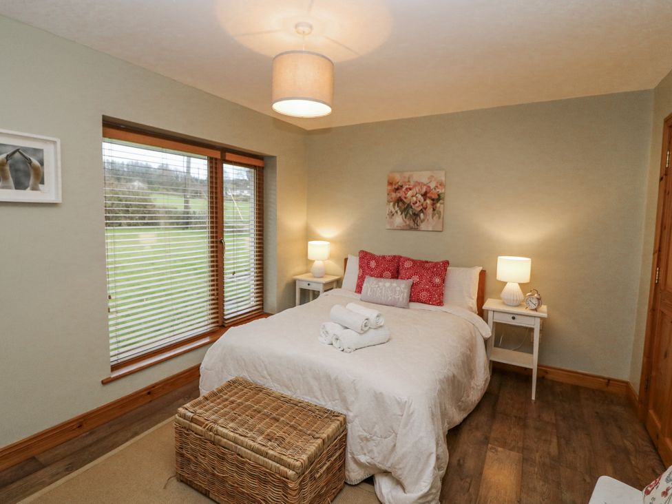 A bedroom with a bed and nightstands at Lough Cluhir Cottage, Union Hall, County Cork