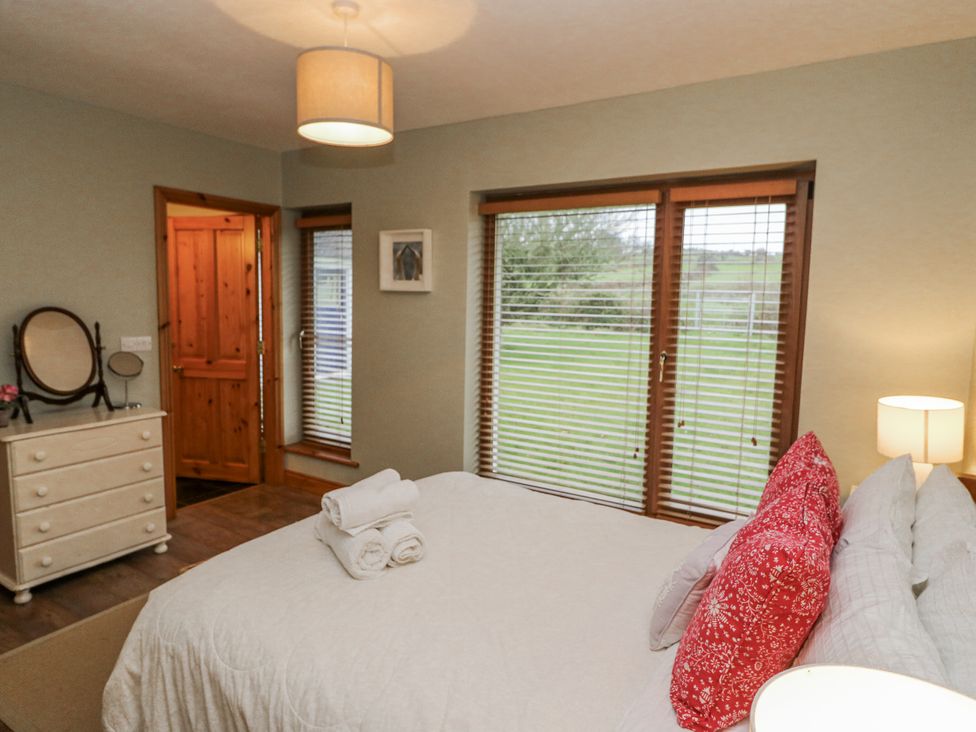 A bedroom with a bed and dresser at Lough Cluhir Cottage, Union Hall, County Cork