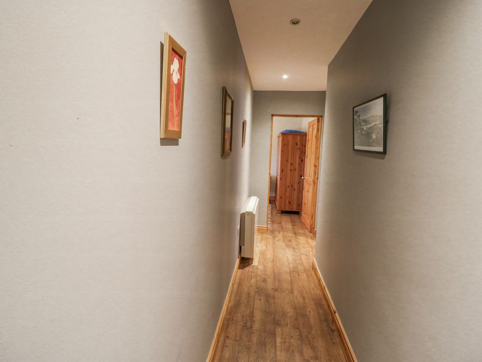 A hallway with artwork on the walls at Lough Cluhir Cottage, Union Hall, County Cork