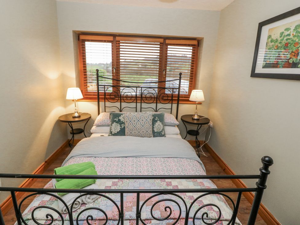 A bedroom with a bed and two lamps at Lough Cluhir Cottage, Union Hall, County Cork