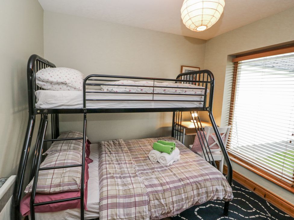 A bedroom with a bunk bed and double bed at Lough Cluhir Cottage in Union Hall, County Cork