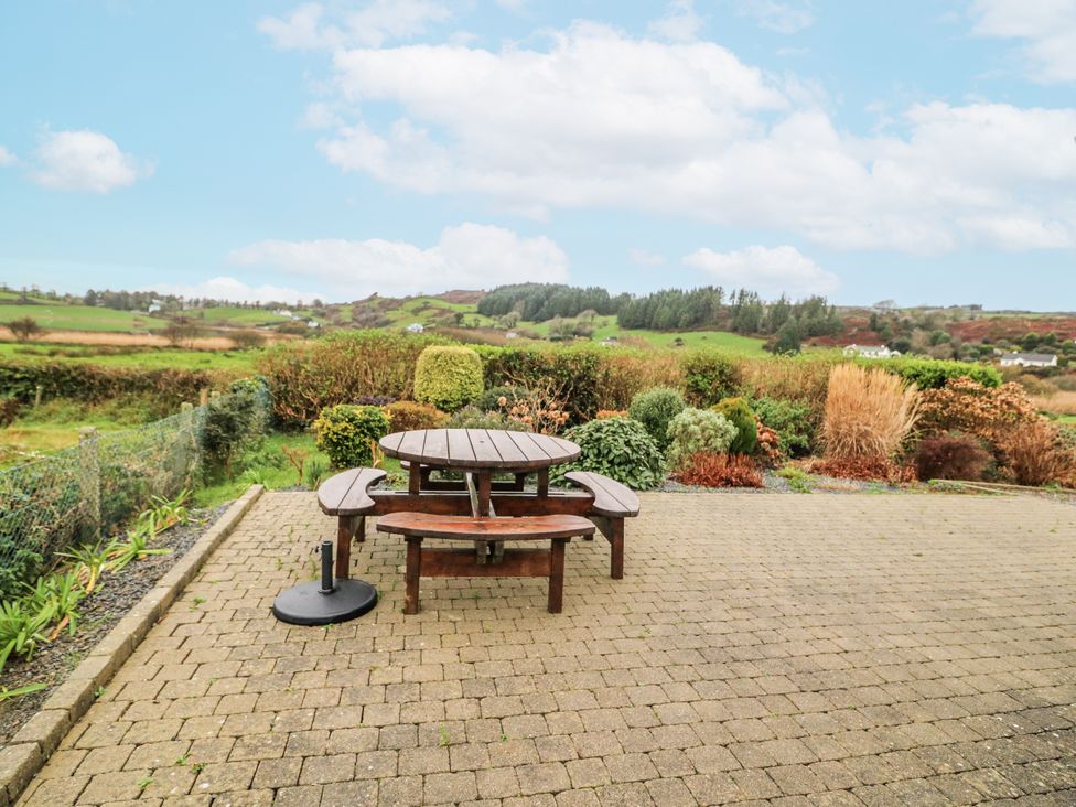 A garden with a picnic table and benches at Lough Cluhir Cottage in Union Hall, County Cork