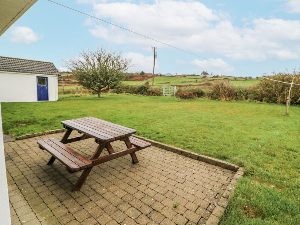 A garden with a picnic table and shed at Lough Cluhir Cottage, Union Hall, County Cork