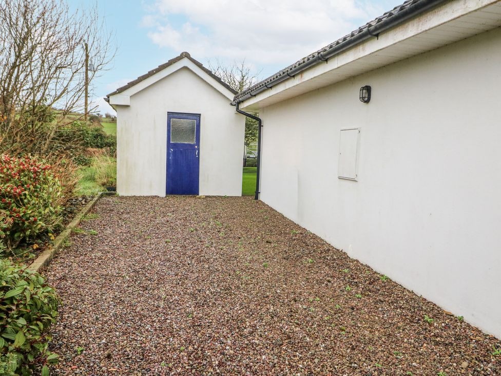 An outdoor area with a gravel pathway and a side building at Lough Cluhir Cottage, Union Hall, County Cork
