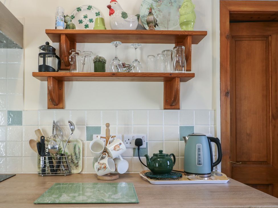 A kitchen with shelf and utensils at Lily Cottage Caeathro near Caernarfon
