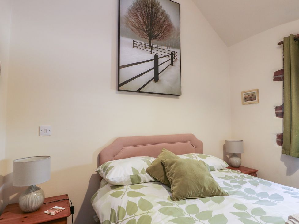 A bedroom with a bed and bedside table at Lily Cottage in Caeathro near Caernarfon