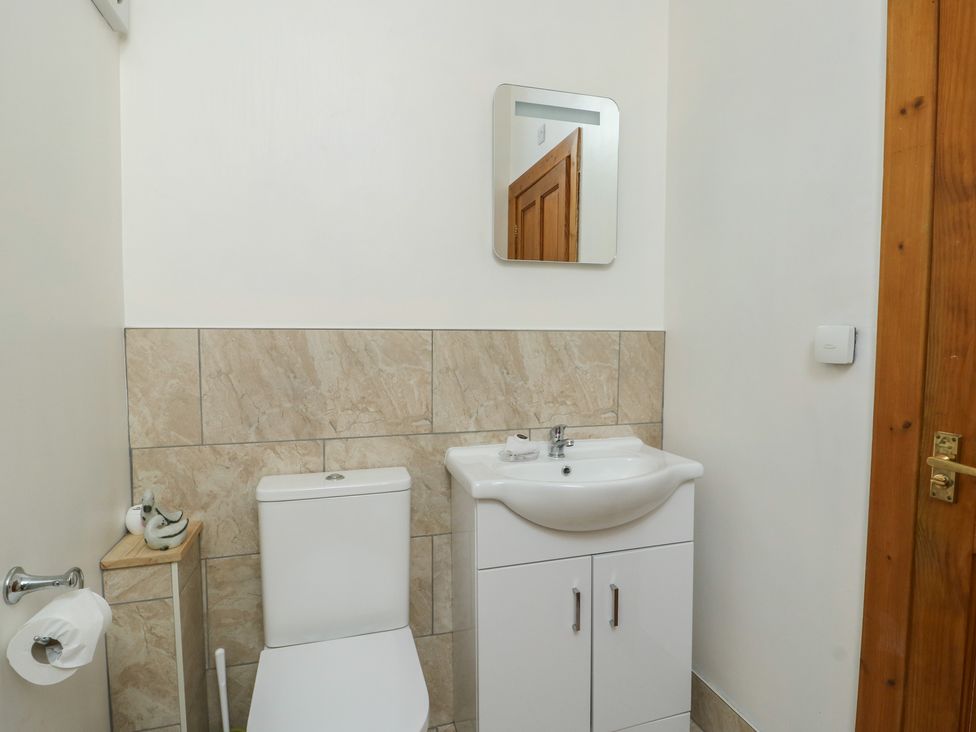 A bathroom with a toilet and sink at Lily Cottage in Caeathro near Caernarfon
