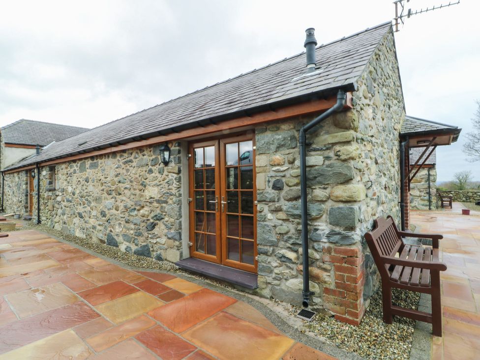 An exterior view of a stone building with double doors at Lavender Cottage Caeathro near Caernarfon