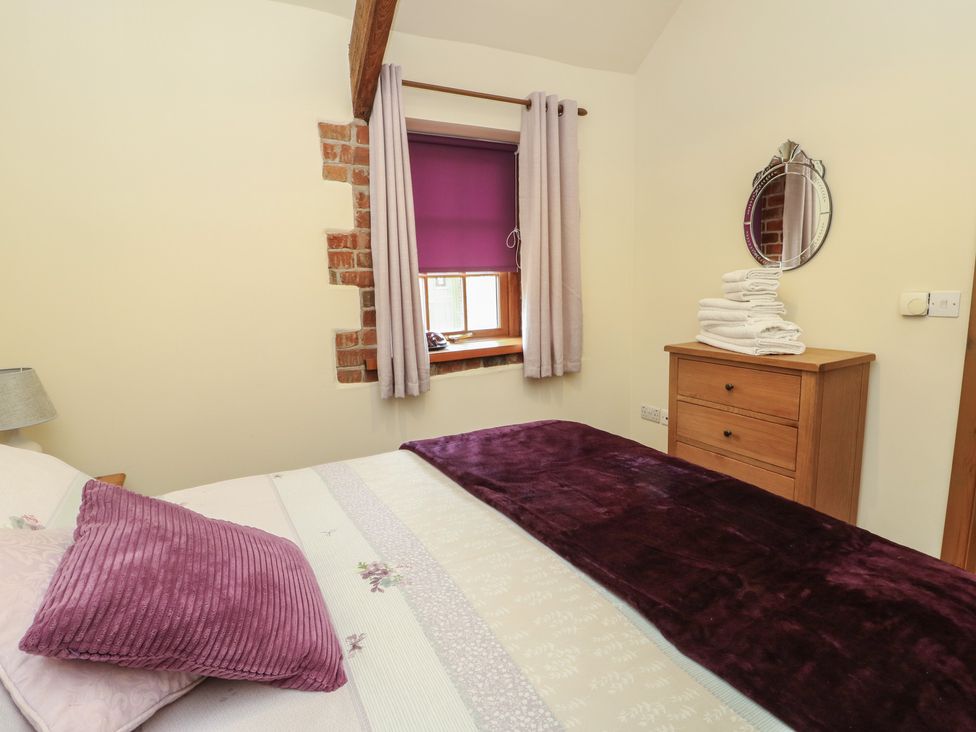 A bedroom with a bed and window at Lavender Cottage in Caeathro near Caernarfon