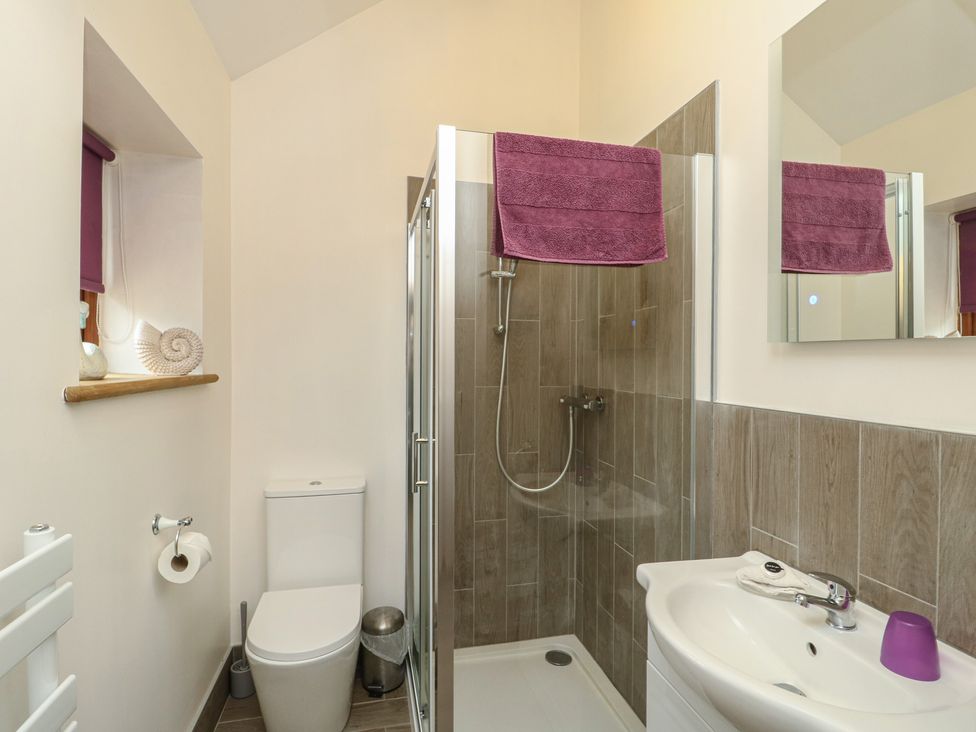 A bathroom with a shower and sink at Lavender Cottage in Caeathro near Caernarfon