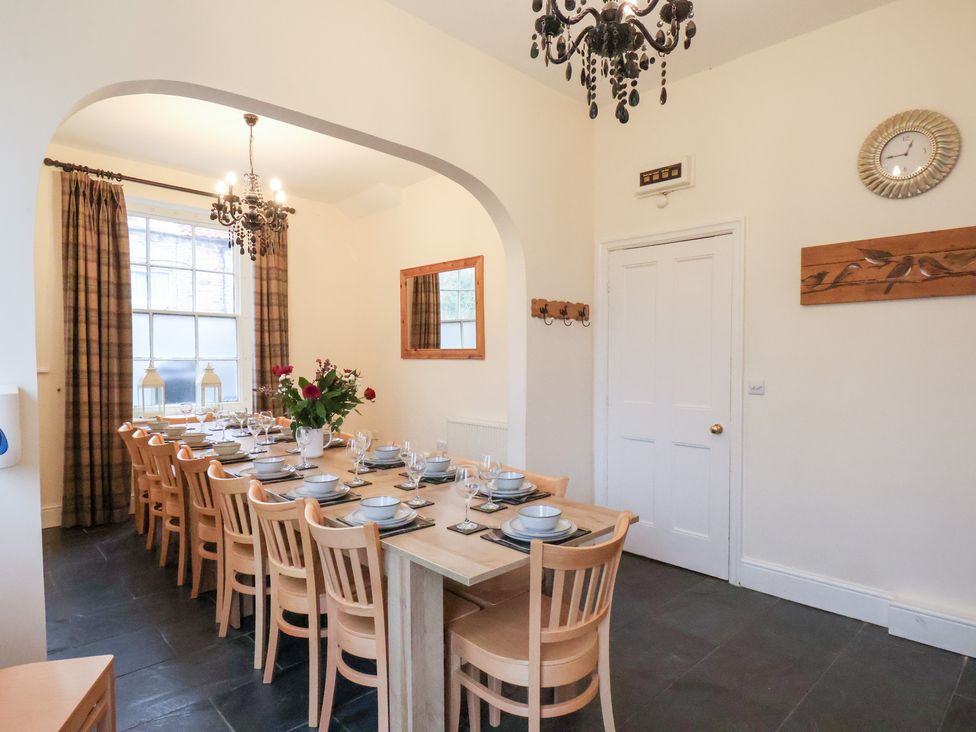 A dining room with a large table set for a meal at The Lodge in Snainton near Scarborough