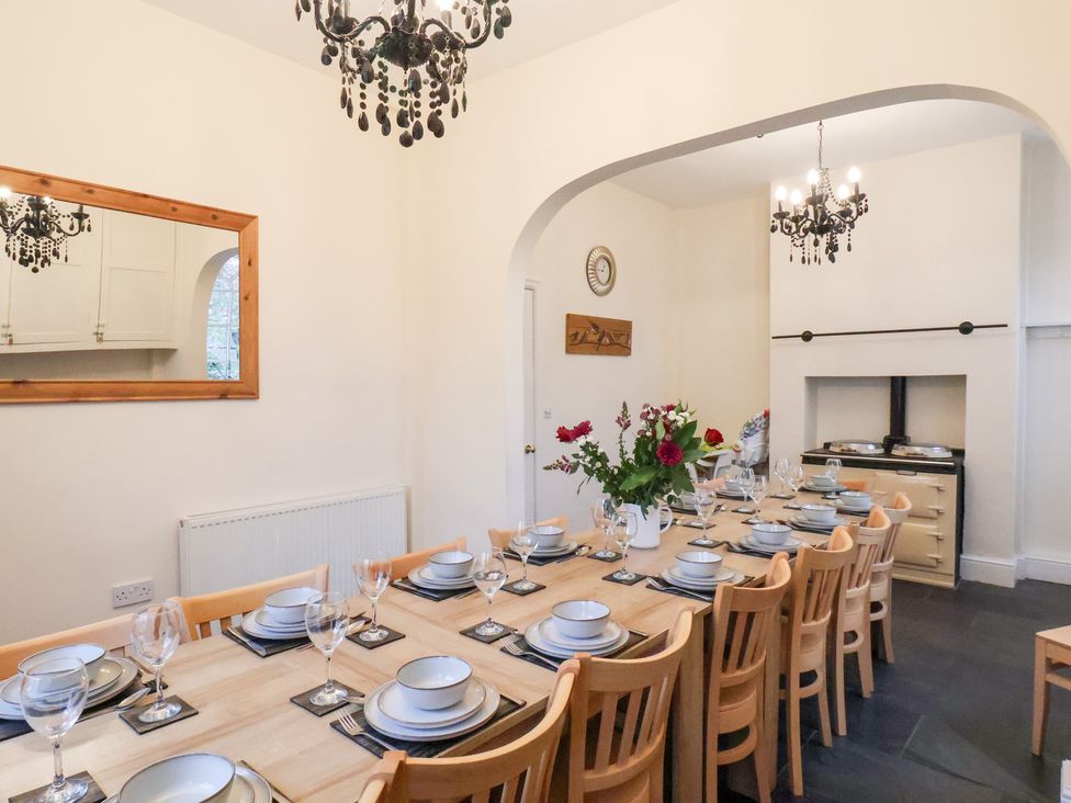 A dining room with a long table set for a meal at The Lodge in Snainton near Scarborough