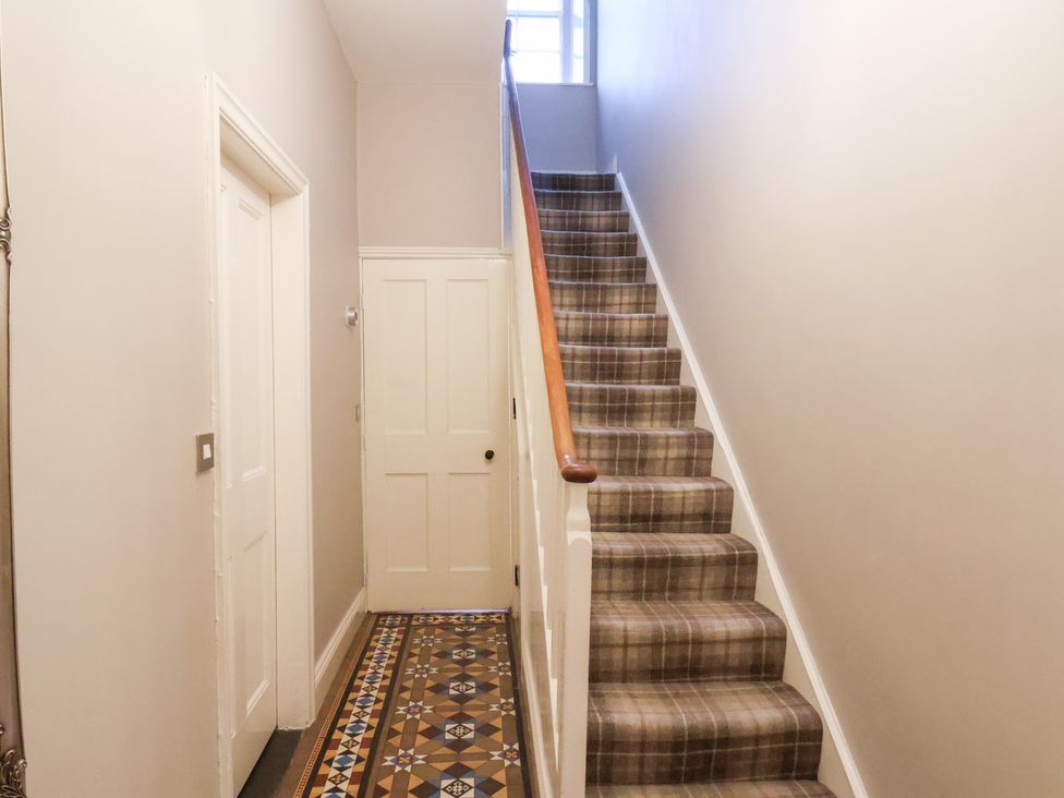 A hallway with stairs and patterned flooring at The Lodge Snainton near Scarborough