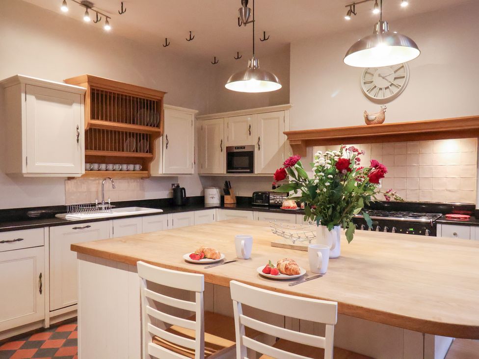A kitchen with an island and flowers at The Lodge in Snainton near Scarborough