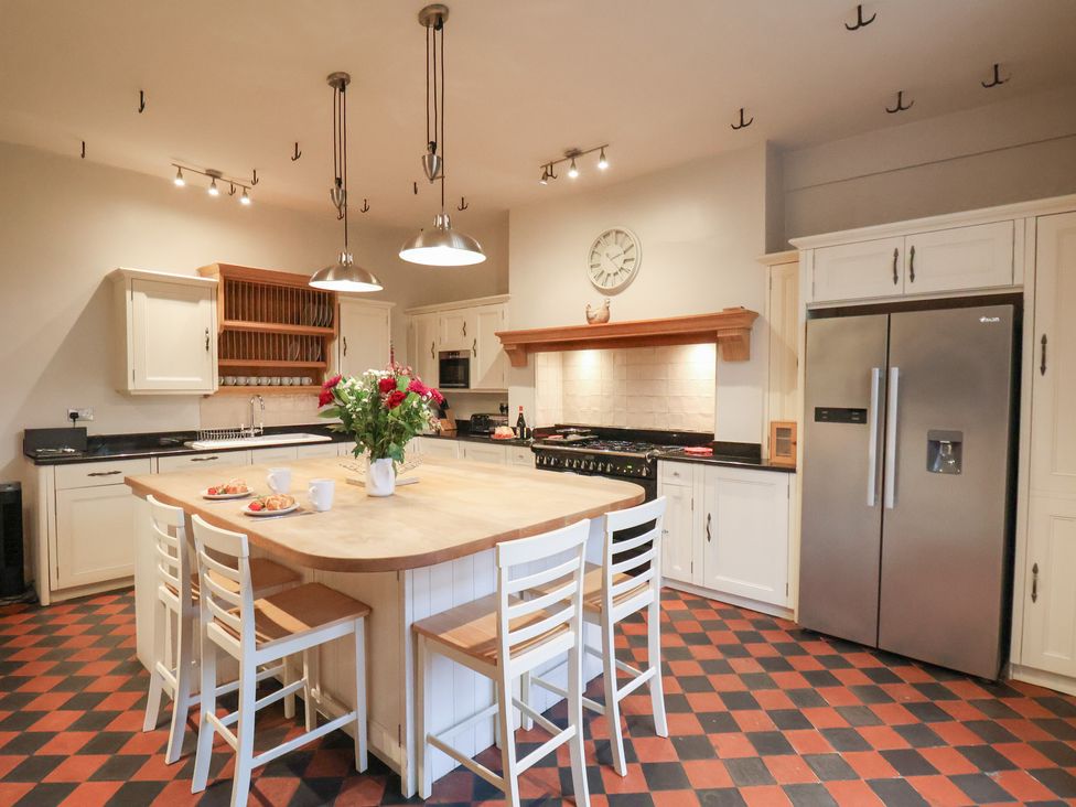 A kitchen with an island and stools at The Lodge in Snainton near Scarborough