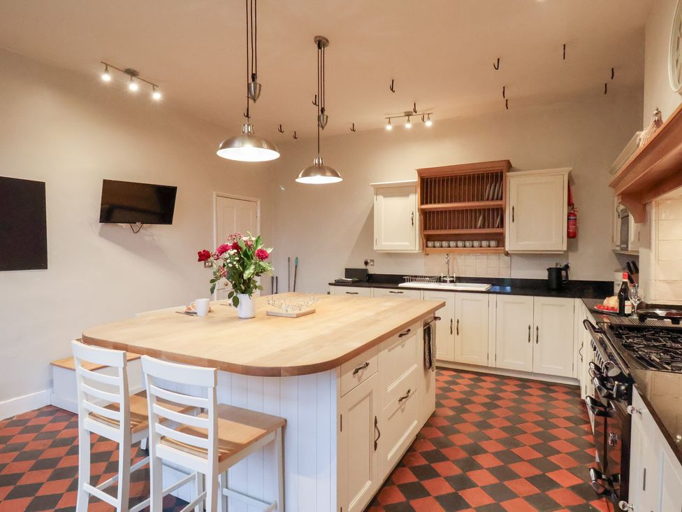 A kitchen with an island and stools at The Lodge in Snainton near Scarborough