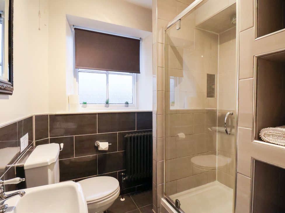 A bathroom with a toilet, sink, and shower at The Lodge in Snainton near Scarborough