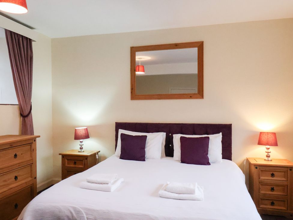A bedroom with a bed and bedside tables at The Lodge in Snainton near Scarborough